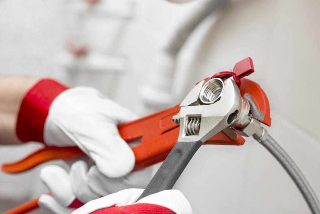 Plumber holding pipe wrenches for an emergency repair in Palm Bay