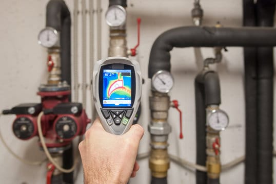 Plumber using a thermal imaging camera to inspect pipes in Palm Bay