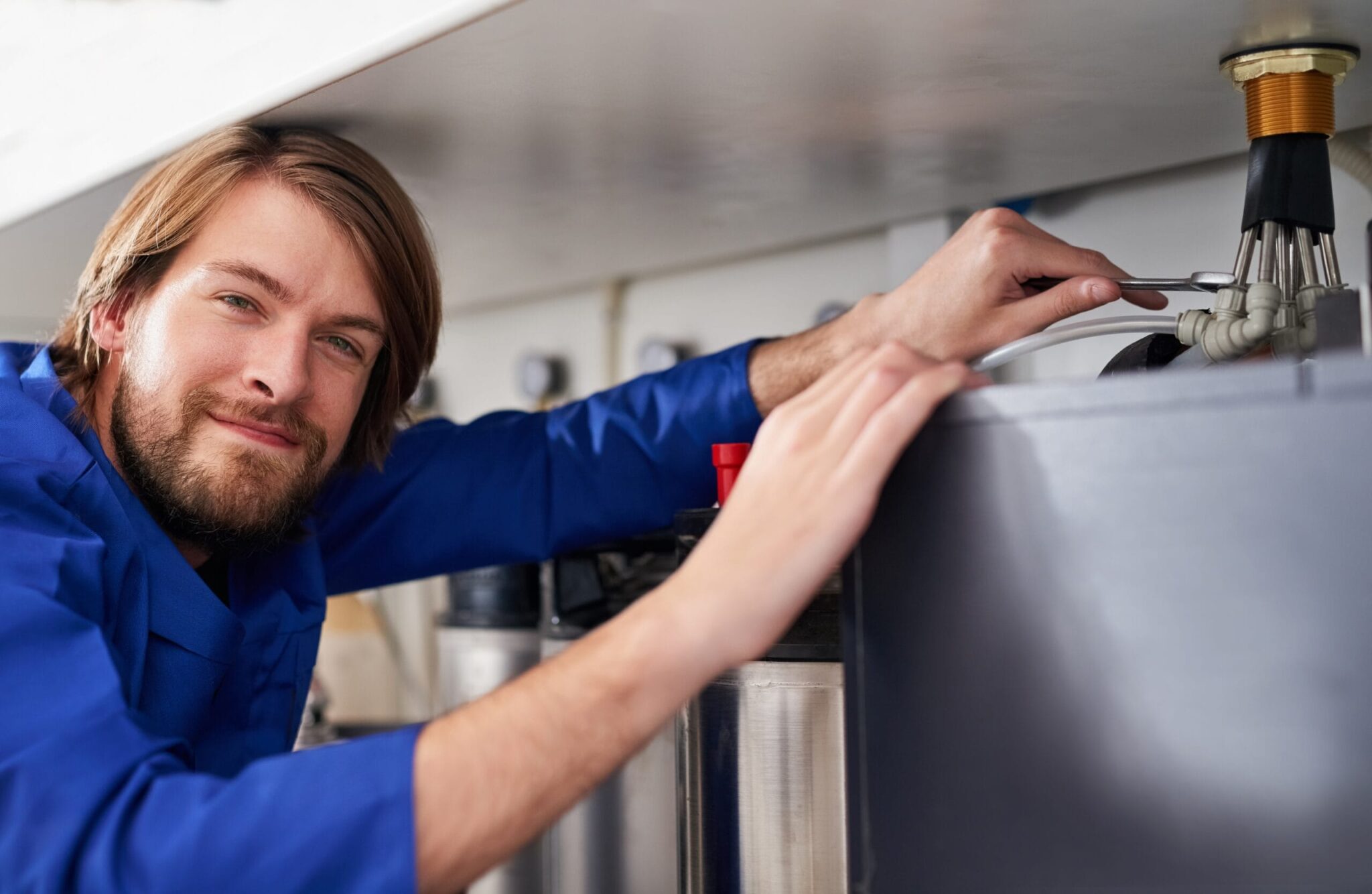 Technician servicing a residential water heater tank in Palm Bay